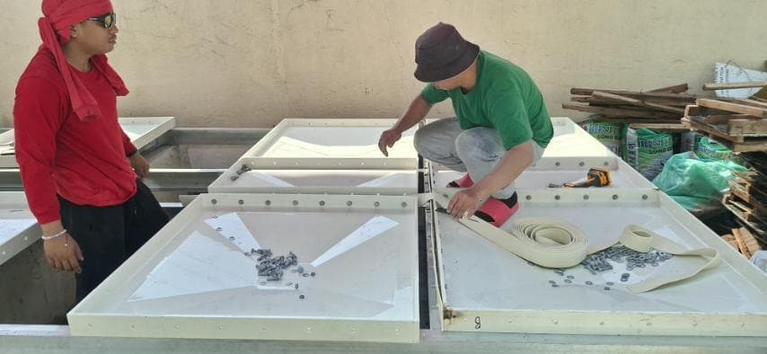 Crew fitting EPDM gaskets and bolts on GRP panels before assembly